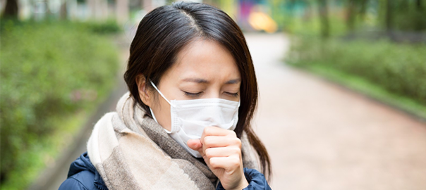 girl wearing mask coughing