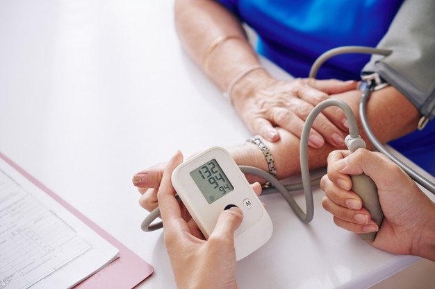 Measuring blood pressure of elderly woman